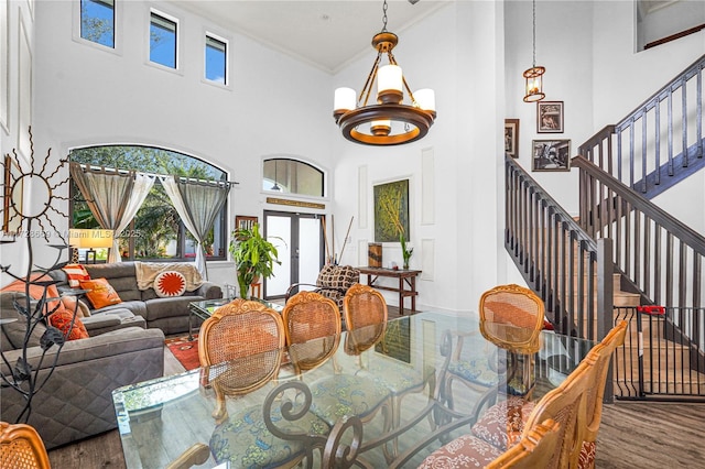 dining room featuring crown molding, french doors, a high ceiling, and hardwood / wood-style flooring