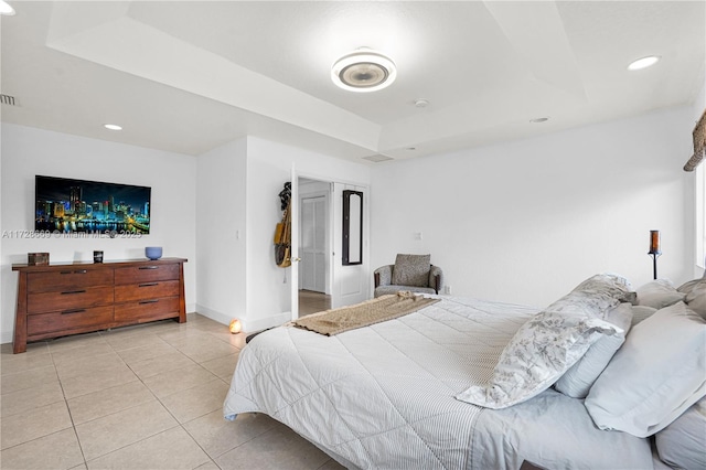 tiled bedroom featuring a tray ceiling