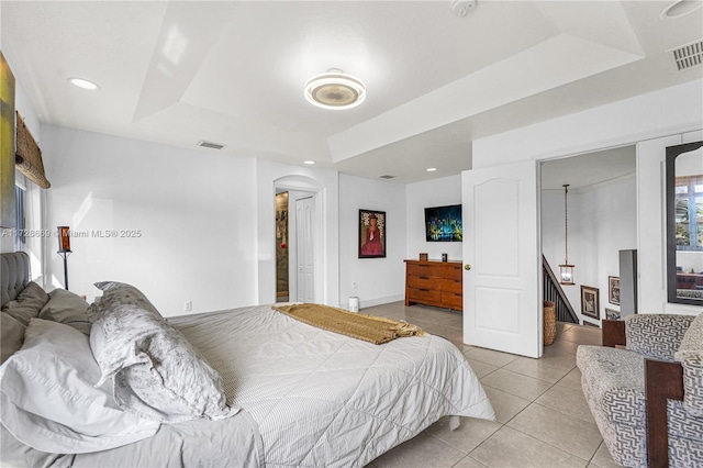 tiled bedroom featuring a raised ceiling