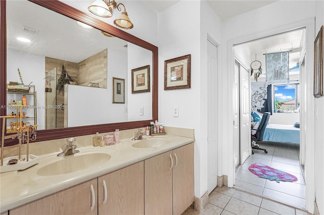 bathroom with a tile shower, tile patterned floors, and vanity