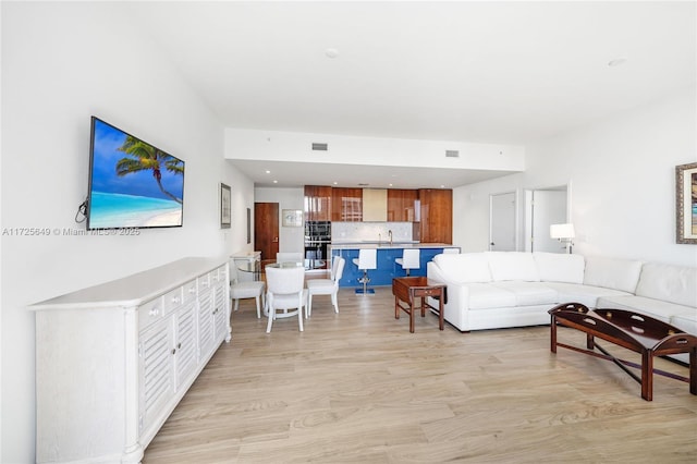 living room with sink and light wood-type flooring