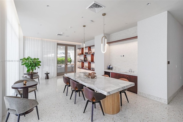 dining area with sink, french doors, and brick wall