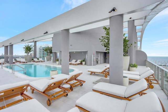 view of pool with a water view and a patio area