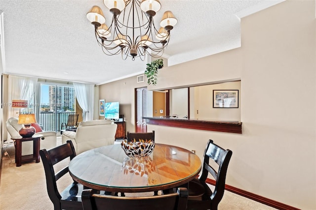 dining room featuring a textured ceiling, a notable chandelier, light colored carpet, baseboards, and ornamental molding