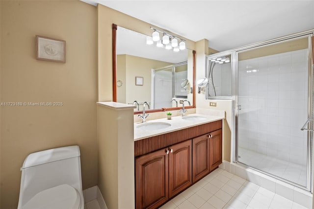 full bathroom with double vanity, a shower stall, toilet, and a sink