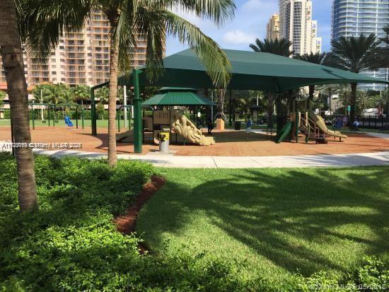 community jungle gym featuring a lawn and a city view