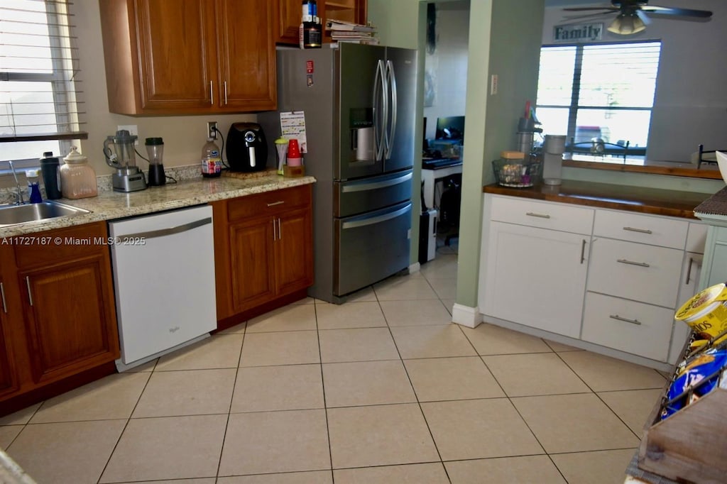 kitchen with light tile patterned floors, stainless steel fridge, ceiling fan, dishwasher, and sink