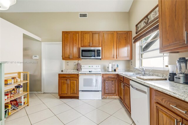 kitchen featuring light stone counters, white appliances, and light tile patterned flooring