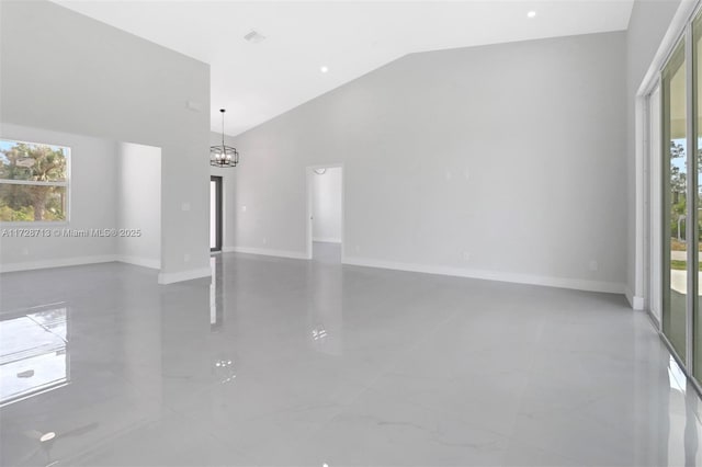 empty room featuring high vaulted ceiling and a notable chandelier