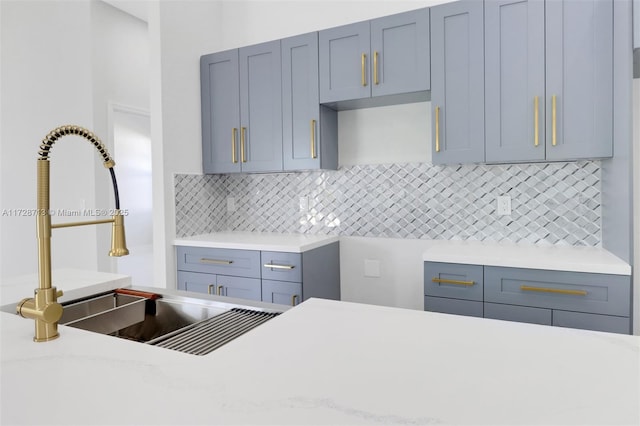 kitchen featuring light stone countertops, sink, and tasteful backsplash