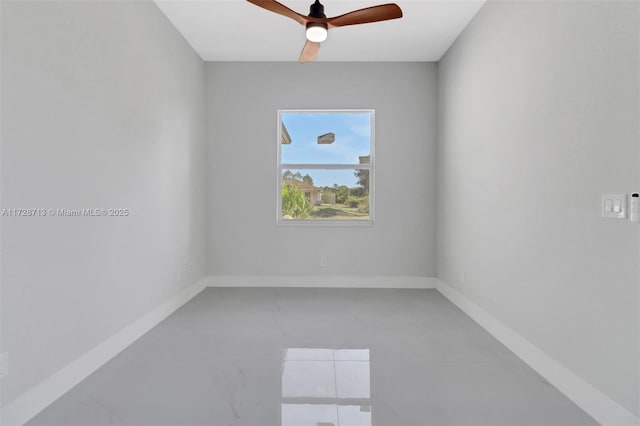 spare room with ceiling fan and concrete floors