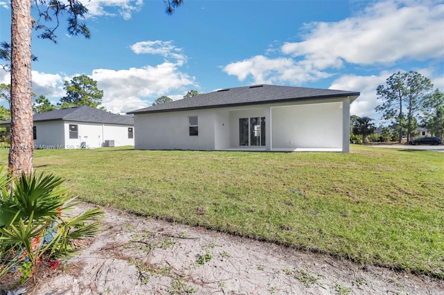 back of house with central AC and a lawn