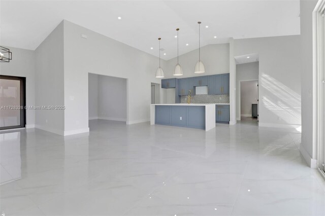 kitchen with backsplash, a kitchen island, hanging light fixtures, high vaulted ceiling, and blue cabinets