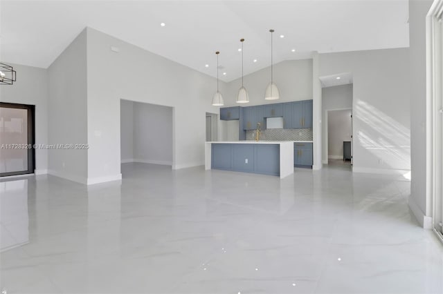 kitchen with high vaulted ceiling, a center island, decorative backsplash, blue cabinets, and decorative light fixtures