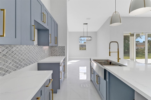 kitchen with sink, decorative backsplash, a healthy amount of sunlight, and decorative light fixtures