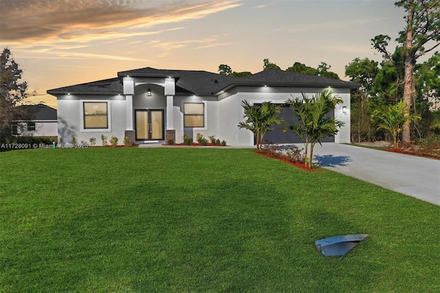 contemporary house with a lawn, french doors, and a garage