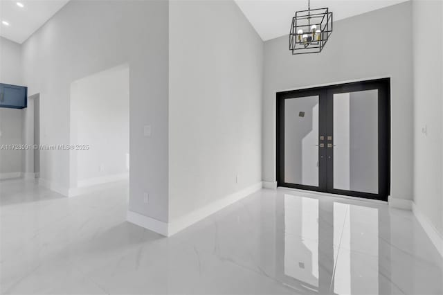 foyer entrance with french doors and a notable chandelier