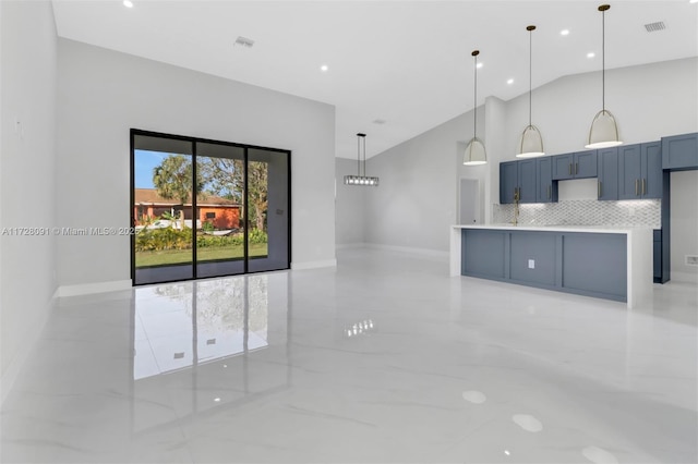 kitchen featuring blue cabinetry, tasteful backsplash, vaulted ceiling, hanging light fixtures, and kitchen peninsula