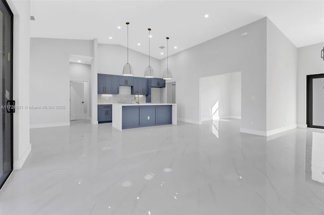 kitchen with sink, high vaulted ceiling, tasteful backsplash, blue cabinets, and decorative light fixtures