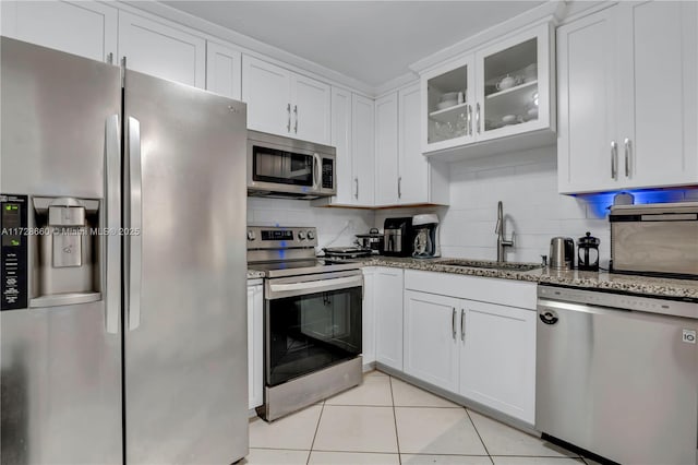 kitchen featuring stainless steel appliances, white cabinetry, sink, and light tile patterned floors