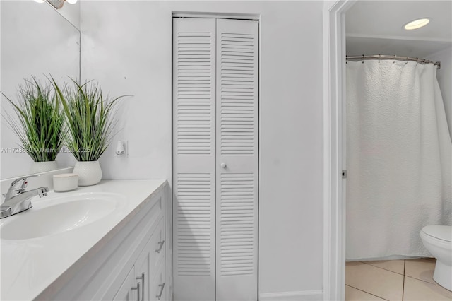 bathroom with tile patterned flooring, vanity, and toilet