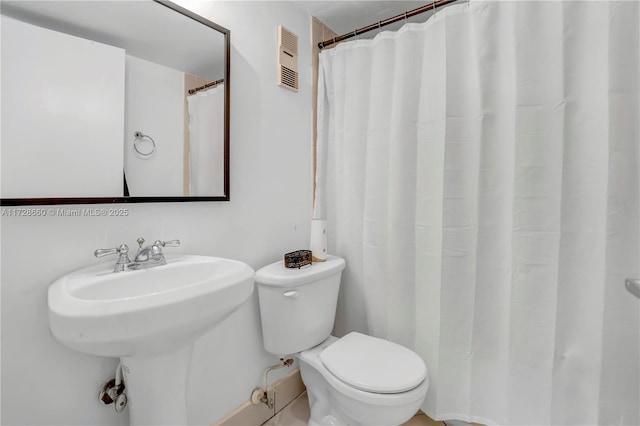 bathroom featuring sink, toilet, and walk in shower