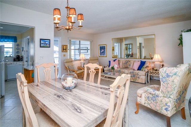 dining room with a textured ceiling, light tile patterned floors, and an inviting chandelier