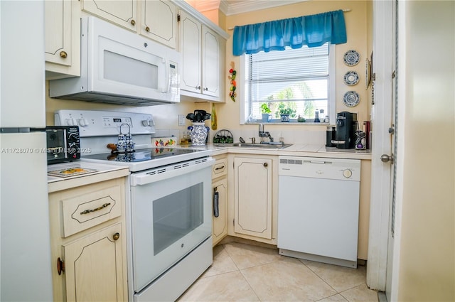 kitchen with light tile patterned floors, sink, and white appliances