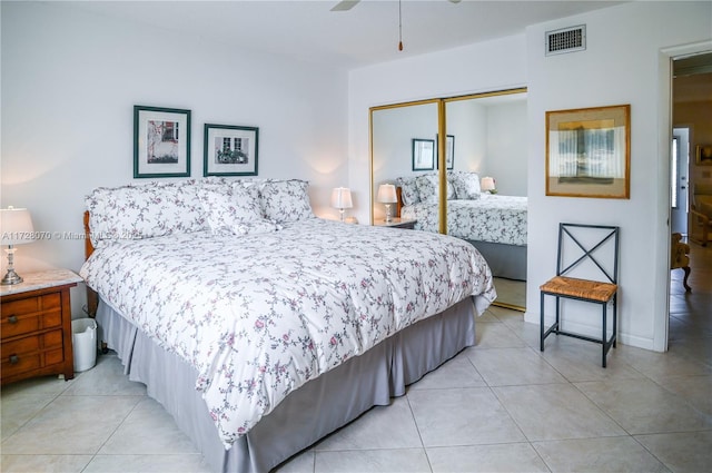 bedroom with ceiling fan, light tile patterned floors, and a closet