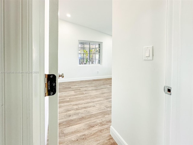 hall featuring light hardwood / wood-style flooring and vaulted ceiling