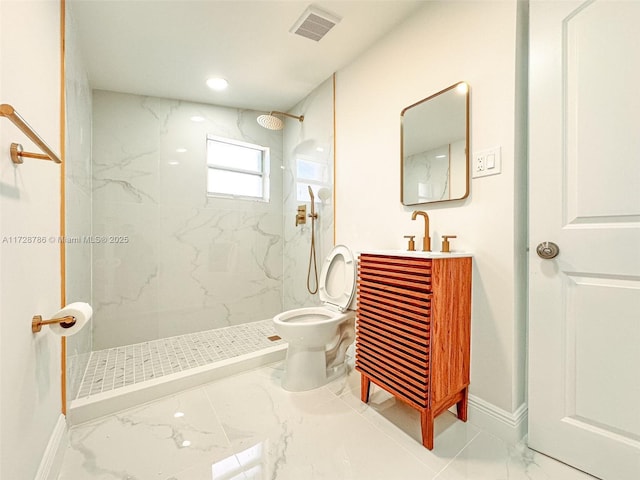 bathroom featuring tiled shower, toilet, and vanity