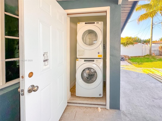 clothes washing area with stacked washer and dryer