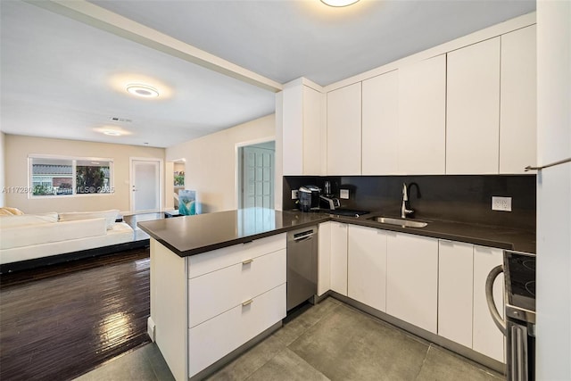 kitchen featuring kitchen peninsula, appliances with stainless steel finishes, sink, and white cabinetry