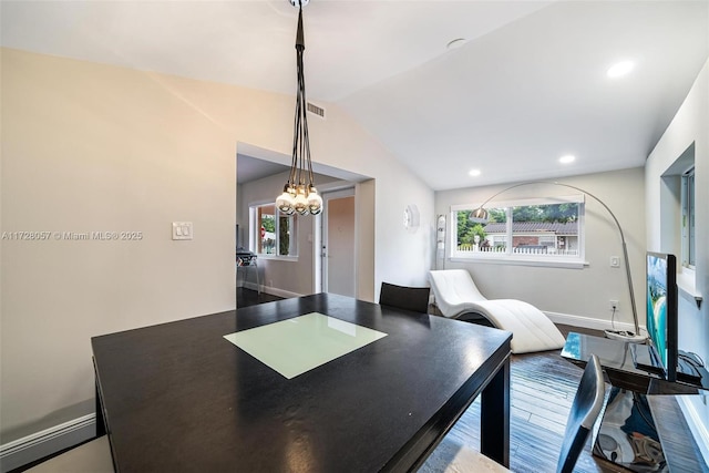 dining room with vaulted ceiling, a healthy amount of sunlight, and hardwood / wood-style floors