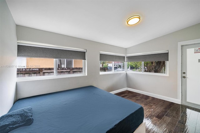 unfurnished bedroom featuring lofted ceiling and hardwood / wood-style floors