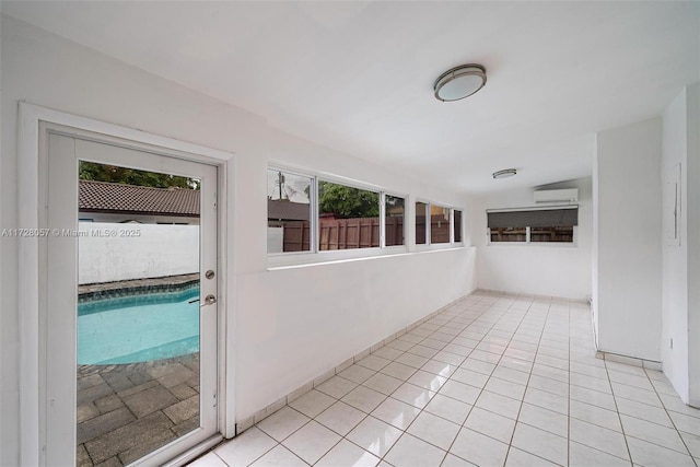 unfurnished sunroom with an AC wall unit and plenty of natural light