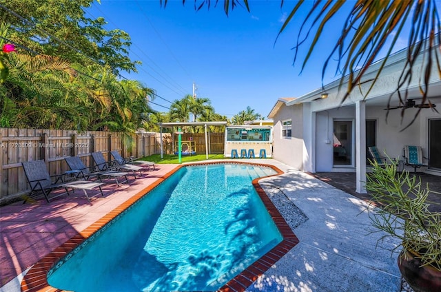 view of swimming pool with ceiling fan and a patio area