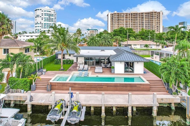 back of house featuring a pool with hot tub, a water view, and a patio area