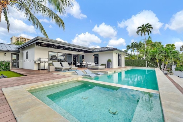 rear view of property featuring an outdoor hangout area, an outdoor kitchen, and a swimming pool side deck