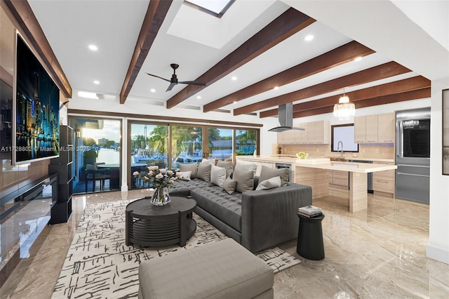 living room with beam ceiling, a skylight, and plenty of natural light