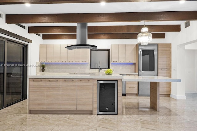 kitchen with island exhaust hood, backsplash, wine cooler, hanging light fixtures, and beam ceiling