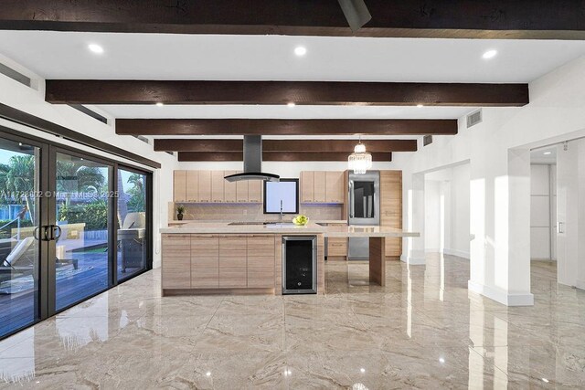 kitchen with backsplash, island range hood, beam ceiling, and wine cooler