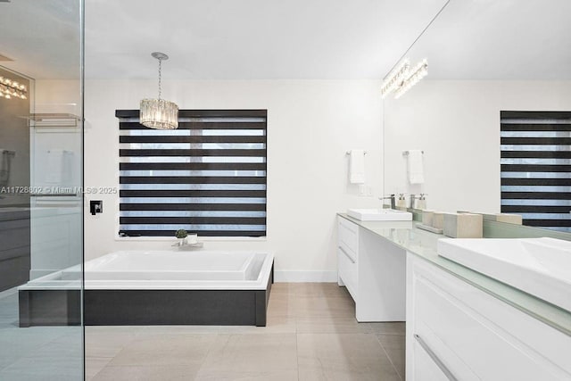 bathroom with a bath, tile patterned flooring, a chandelier, and vanity