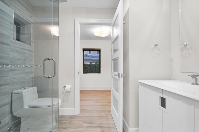 bathroom with toilet, vanity, and an enclosed shower