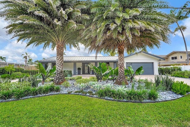 view of front of property featuring a front lawn and a garage