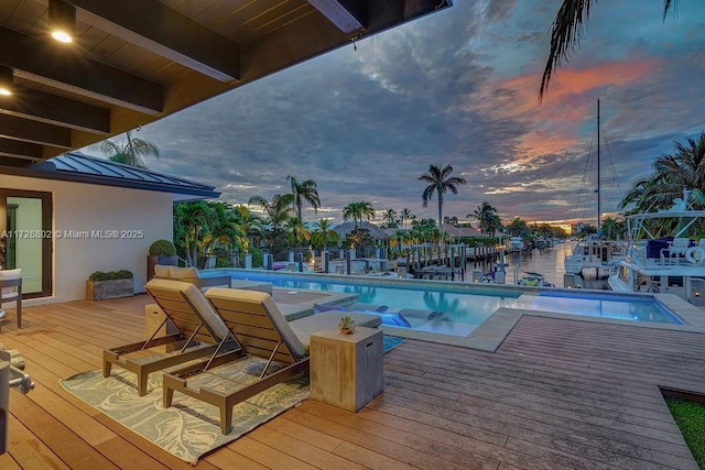 pool at dusk with a deck with water view