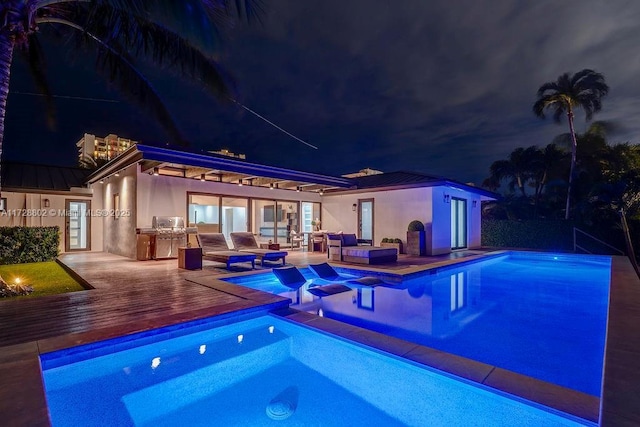 pool at twilight featuring a deck and outdoor lounge area