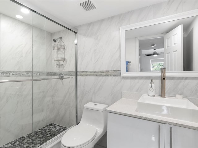 bathroom featuring tile walls, an enclosed shower, vanity, and toilet