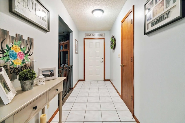 entryway with a textured ceiling and light tile patterned floors