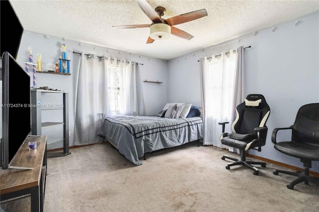 bedroom with a textured ceiling, ceiling fan, and carpet flooring